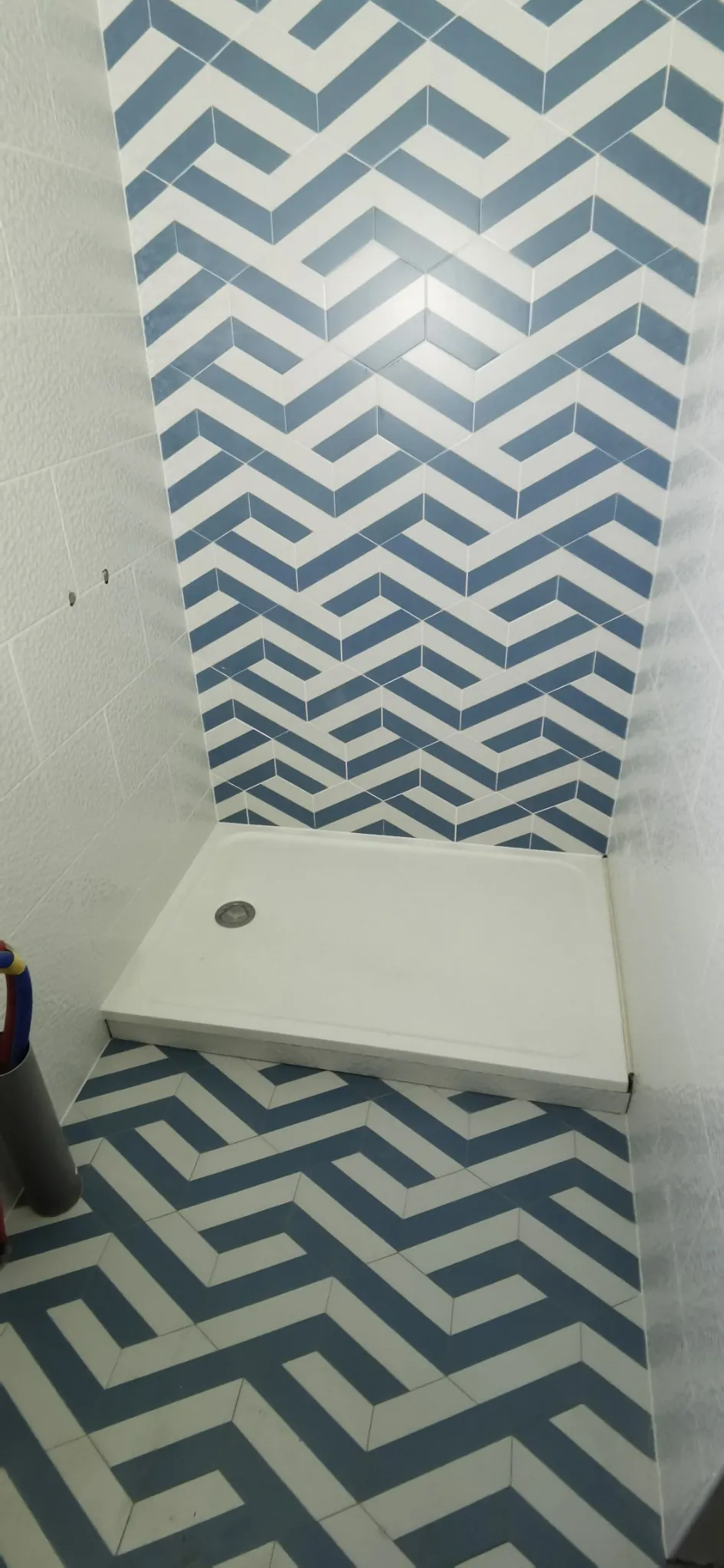 Mur de douche habillé de faïence posée en chevrons bleu-gris, réalisation Ducroc
